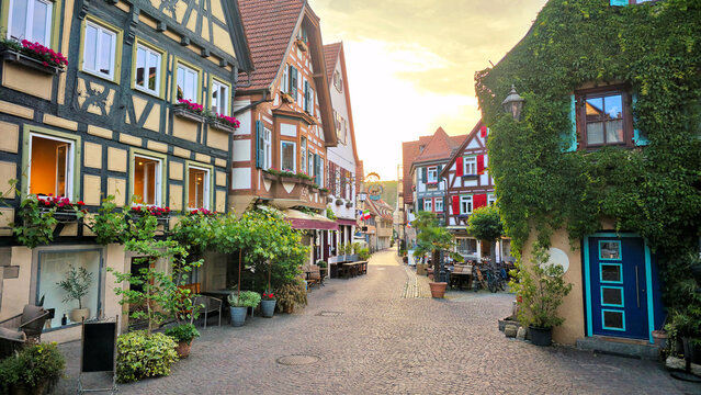 Half timbered architecture of the beautiful village of Besigheim, Germany. Leafy cobblestone street at sunset.