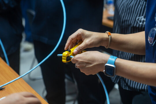 People Connecting Ethernet Cables in Tech Workshop