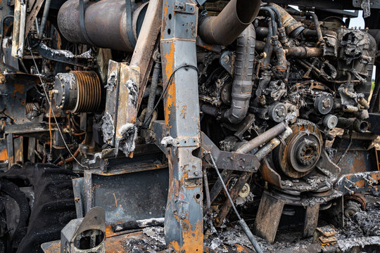 Brandschaden am Motorraum und der Mechanik eines ausgebrannten Feldh&auml;ckslers in Detailaufnahme.