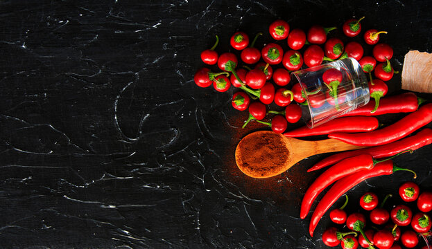 Vibrant red chili peppers on rustic wooden board with spices and garlic	