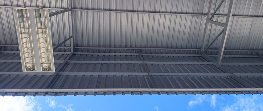 Metal sheet roof curve on blue sky. Modern construction, Metal ribbed arch span roof covering, Large building roof. not ai
