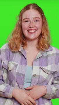 Amused lovely woman pointing finger to camera, laughing out loud, taunting making fun of ridiculous appearance, funny joke anecdote. Pretty redhead girl isolated alone on green chroma key background