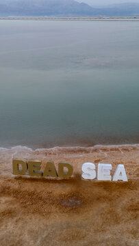 overhead aerial view of dead sea large letter inscription on salt beach in ein bokek israel
