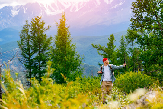 Happy hipster traveler taking selfie and recording video in beautiful mountains, concept travel vlog