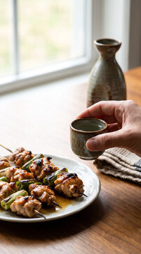 Sake with yakitori featuring grilled chicken skewers and a traditional cup. Classic Japanese izakaya food pairing for World Sake Day and authentic dining experiences