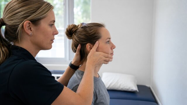 Therapist performing vestibular head impulse test on patient