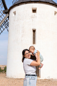 Mother holding baby visiting traditional windmill in Tembleque Toledo