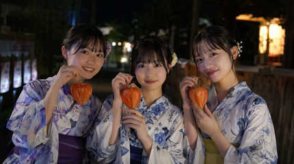 Fototapeta premium ほおづきを手にした３人の浴衣姿の女の子（若い女性）日本人の夏