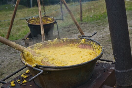 Paiolo o pentola  di rame fumante di polenta  con mestolo in legno