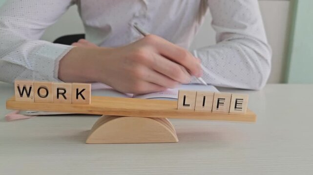 Balancing work and life with wooden blocks and a pen on the table