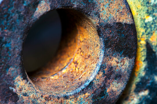 Industrial close-up of a circular hole in a thick steel plate, an angle to emphasize material thickness, rough surface texture, and naturally developed corrosion. Abstract industrial detail of aged me