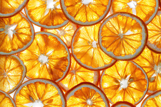 Abstract glowing background of translucent orange fruit slices by backlight. Aesthetic food Natural geometric pattern. Vibrant texture for summer design, menus, and wellness layouts, yellow gradient.