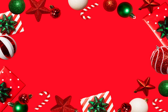 Festive Christmas background with ornaments, gifts, stars and candy canes framing a large red copy space. Ideal for cards, banners, invitations, social media and holiday advertising.