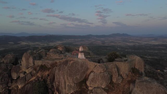 Triangulation pillar overlooking Monsanto, Portugal, with panoramic views across mountains and valleys. Historic high point surrounded by granite rocks and dramatic landscapes.