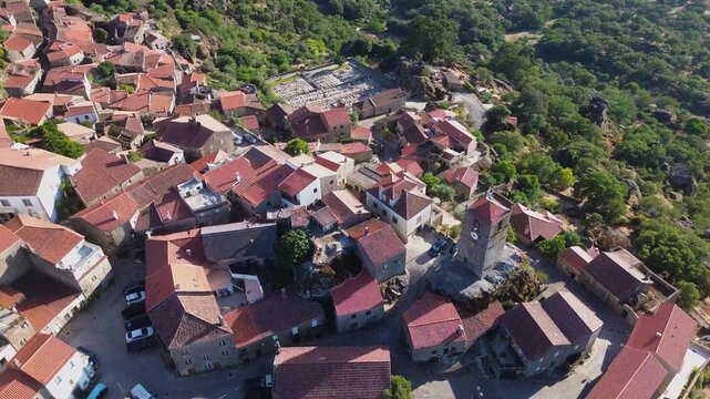 Aerial panoramic view of Monsanto, Portugal, the historic stone village built among massive granite boulders. Traditional red-roofed houses blend into the dramatic mountain landscape.