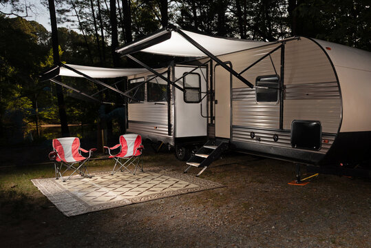 Camper trailer set up in a forest with awnings out