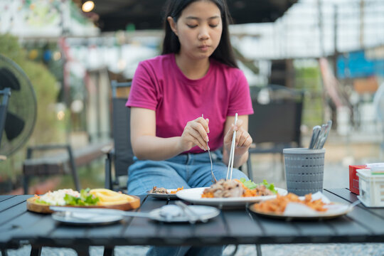 Young woman enjoying a delicious meal at an outdoor restaurant table