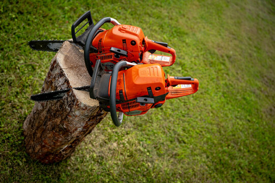 Zaube, Latvia &ndash; August 2, 2026: Two Husqvarna chainsaws displayed on a cut tree trunk during an outdoor forestry and machinery event.