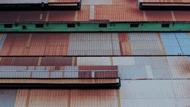 Top down tracking view over an industrial metal roof showcasing geometric rust textures and metallic details. High contrast architectural composition for background VFX, commercial video, and document