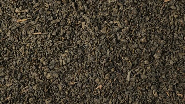 Dried green tea leaves rotating background