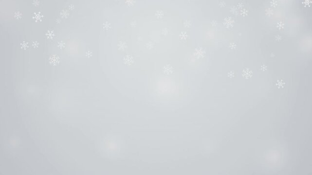 Elegant white snowflakes falling on light grey background creates peaceful winter atmosphere for holiday season video project.