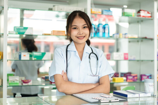 A woman in a white uniform stands in front of a pharmacy counter