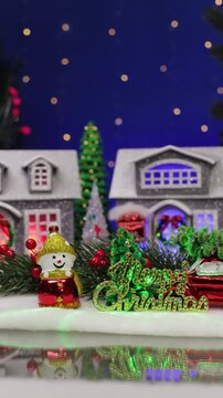 A yellow car drives up to a decorated Christmas village
