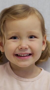 Close up of a charming little girl with herpes simplex sores around her mouth, looking at the camera and smiling, showcasing resilience and a positive outlook despite the skin condition