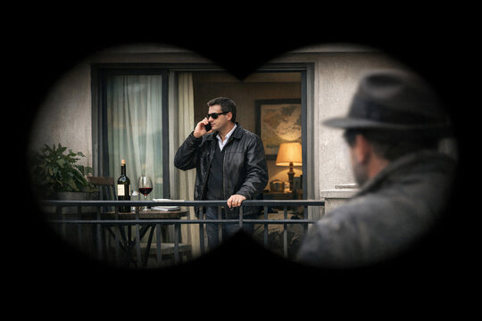 Surveillance of Man Talking on Phone Through Window