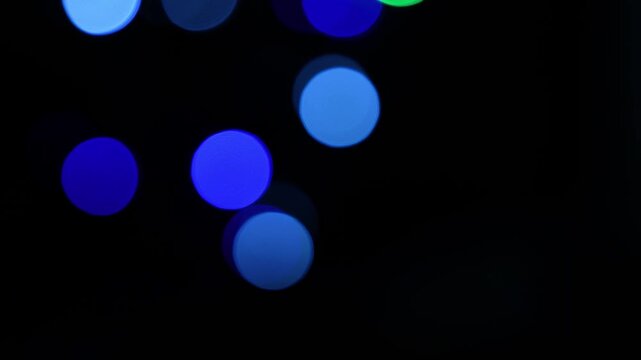 Abstract out of focus colored light circles on a black background