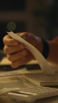 Idea of evening light a soft amber glow illuminates a calculator and scattered receipts on a wooden table in a quiet home, conveying family accounting process, an accountant's careful expense review