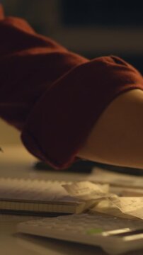 In a home office during the evening, a man sits at a table under evening light and uses a calculator to total expenses, while receipts lie scattered, showing family accounting activity, concept
