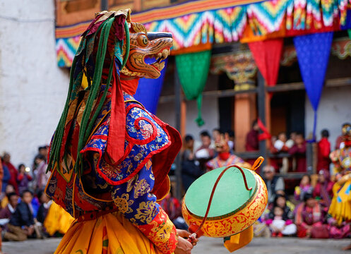 Bhutan, In the village of Bumthang, a monk in colorful costumes dance during the Jakar festival.
