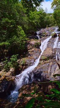 Scenic view of Ngao Waterfall, one of southern Thailand most beautiful waterfalls, flowing through dense green forest beneath the Khao Nom Sao mountain range in Ranong Province. high and wonder