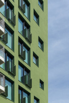 Green modern building facade with residential balconies