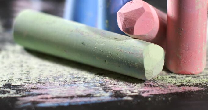 Chalk sticks in various colors on a black surface