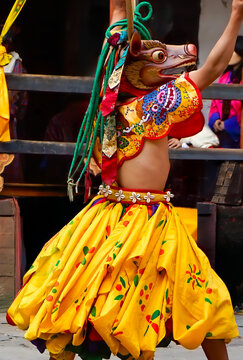 Bhutan, In the village of Bumthang, a monk in colorful costumes dance during the Jakar festival.
