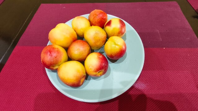 Ripe, smooth nectarines with a bright reddish-yellow blush.