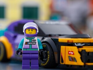 Fototapeta premium Tambov, Russian Federation - January 02, 2026 Portrait of Lego NASCAR Next Gen Chevrolet Camaro ZL1 driver minifigure with his car. LEGO Speed Champions.