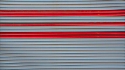 Fototapeta premium Metal Roller Shutter Door Texture Background with Red Horizontal Accent Lines