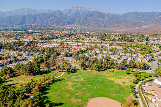 Rancho Cucamonga, California, CA October 8, 2024: High Aerial City Drone View toward Kenyon Way, Highland Ave Community with Homes, Houses, Townhomes, Streets, Roads, Mountain, and Kenyon Way Park
