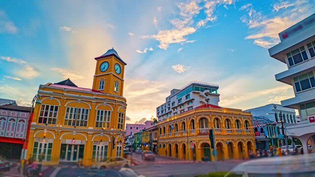 Spectacular sunset over Phuket Old Town featuring the iconic clock tower, heritage buildings, and vibrant tropical clouds captured in time lapse. Colorful Sunset Clouds over Phuket old town