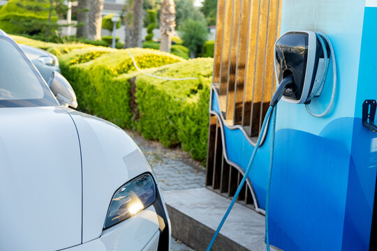 Electric car charging at public station in urban park
