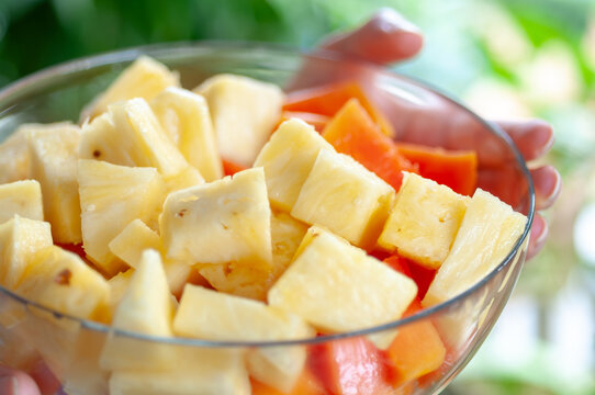 Fresh pineapple and papaya fruit salad in a glass bowl. Tropical combination rich in vitamin C, bromelain, papain and antioxidants for healthy nutrition concepts.