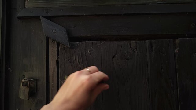 Close up of an old wooden door secured with a rustic horizontal bolt, vintage locking mechanism, home security, traditional architecture, property protection.