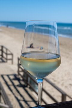 Chilled glass of white wine and sandy beach near Sperlonga, Italy, relaxed seaside holiday atmosphere near popular coastal resort town