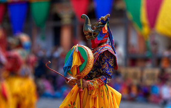 Bhutan, In the village of Bumthang, monks in colorful costumes dance during the annual Jakar festival. blurred background