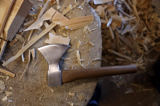 Traditional carving axe on a woodworking bench covered with spruce shavings in a Haut-Jura workshop, France