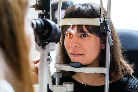 Woman undergo eye examination with slit lamp microscope