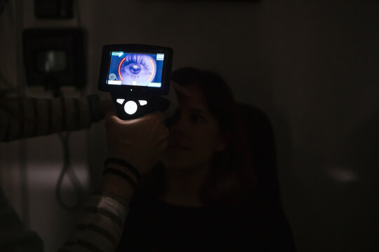 Woman undergoes optic eye examination with digital scanner